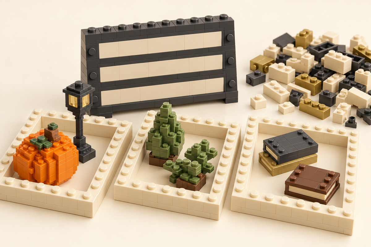 Brick-built sorting trays holding a pumpkin, lamp, plants and books beside a blank board and loose bricks